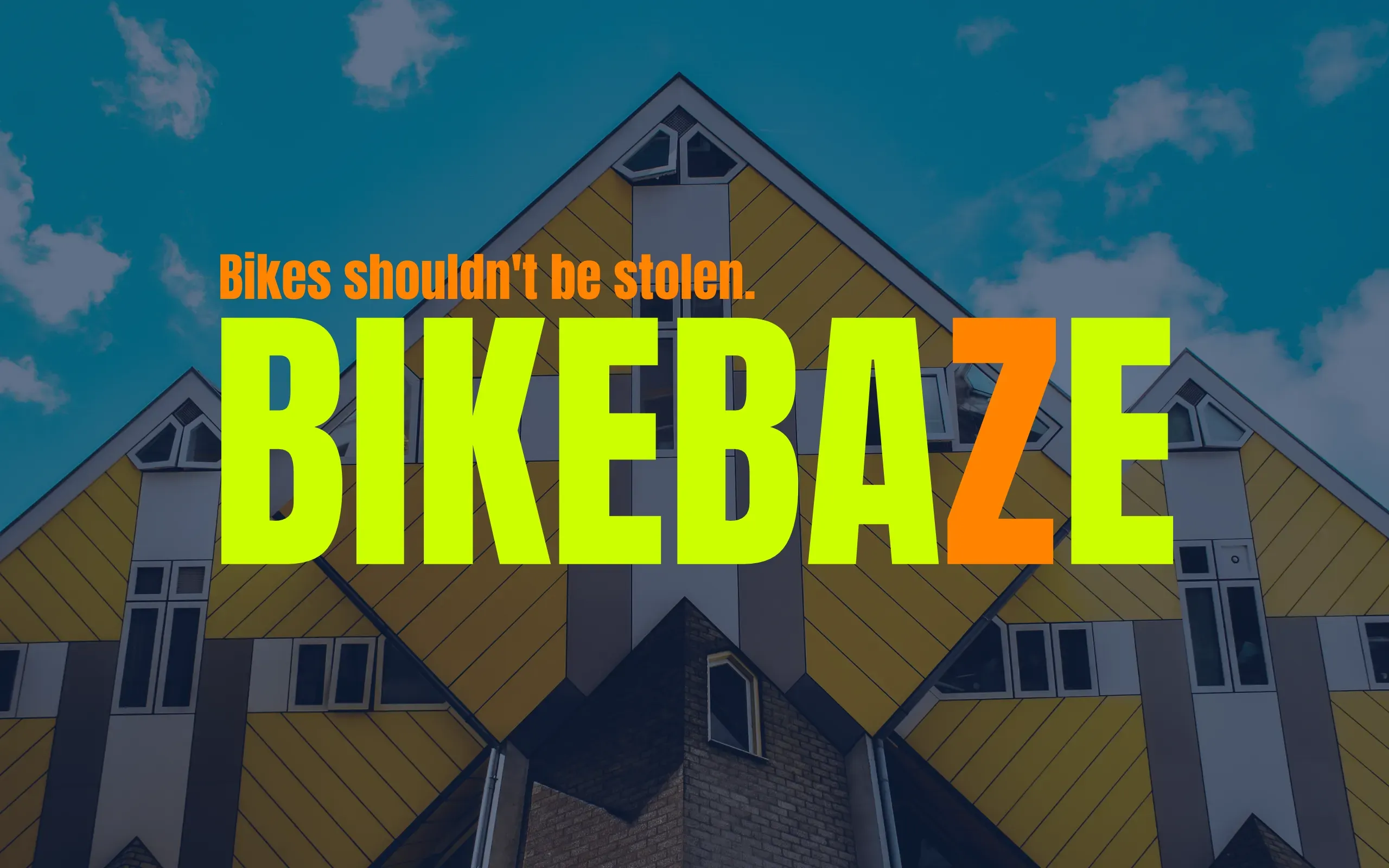 BIKEBAZE logo in geel en oranje boven de gele Kubuswoningen in Rotterdam onder een blauwe lucht.