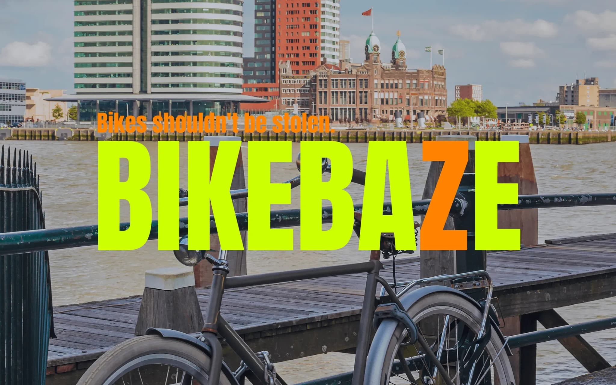 Stadsfiets vastgezet aan een hek bij de Rotterdamse Veerhaven met de skyline van Kop van Zuid op de achtergrond.